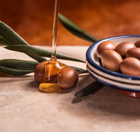 argan oil pouring over argan seeds